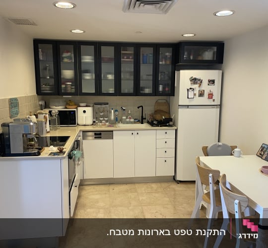 מטבח עם ארונות כהים ומקרר לבן